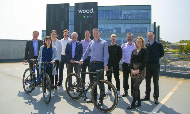A group of staff members and Ride the North Representatives standing with bikes outside the Wood office in Aberdeen