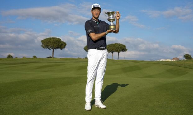 Adrian Meronk holds the trophy after winning the final round of the Italian Open. Image: PA