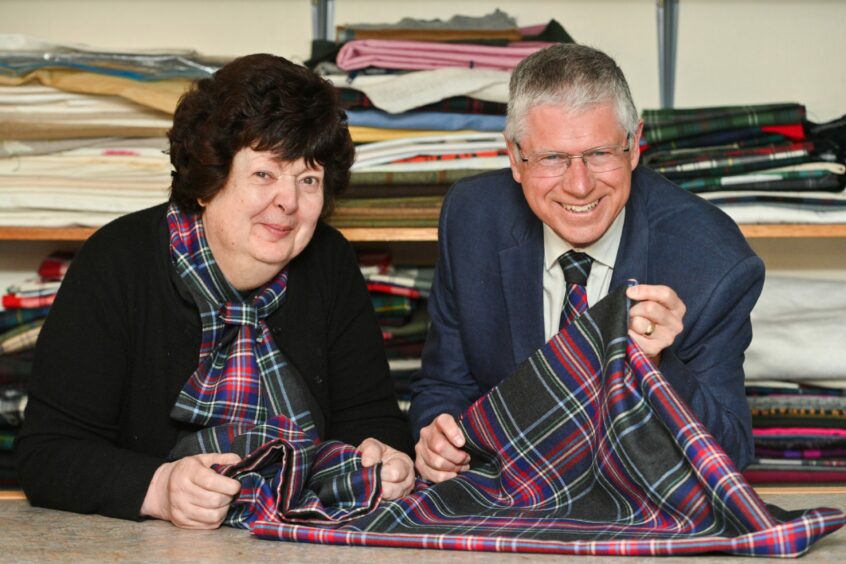 Linda and Andrew Simpson holding the tartan