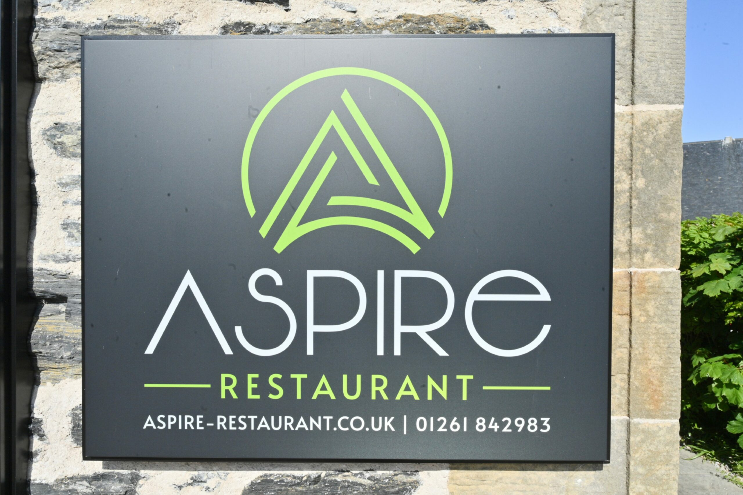 The sign outside reading 'Aspire restaurant - aspire-restaurant.co.uk | 01261 842983
