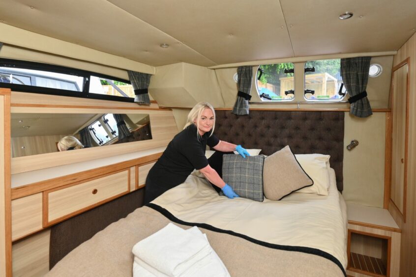 Keri Craib tidying a bedroom in a Caley Cruisers boat.