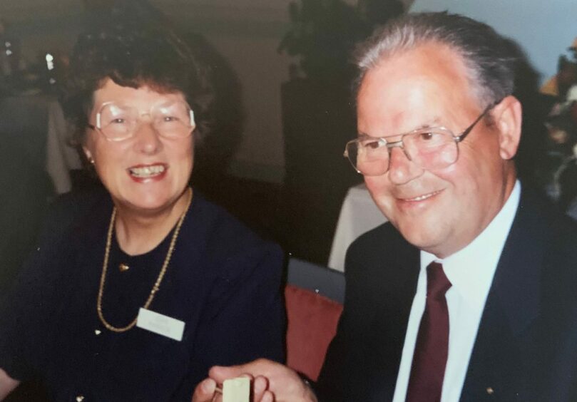 Jean Ramage pictured smiling with her husband, John Ramage MBE, who is wearing a suit and tie. 