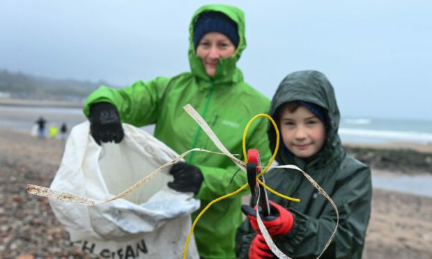 Hayley Thom and seven-year-old Hamish took part in the beach clean in Stonehaven on Monday morning. Image: Kenny Elrick/DC Thomson.