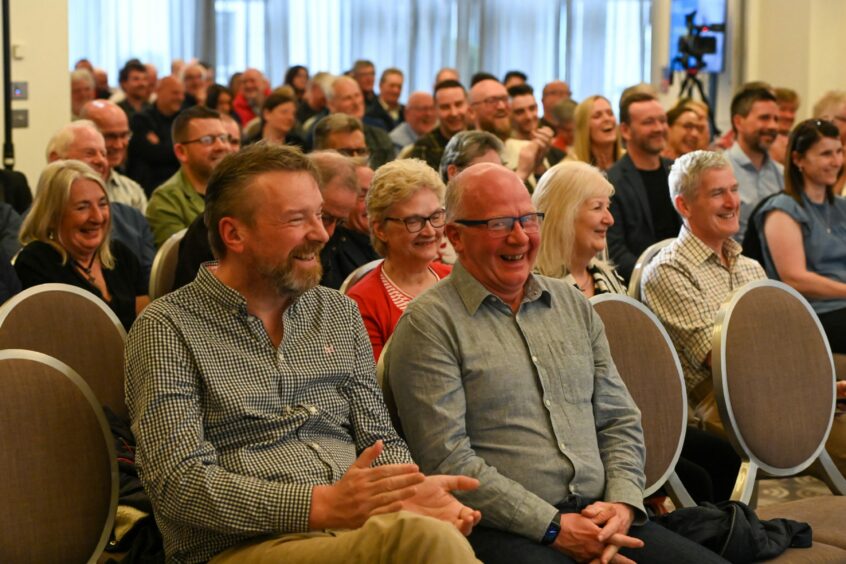 The crowd laugh at one of Willie's stories.