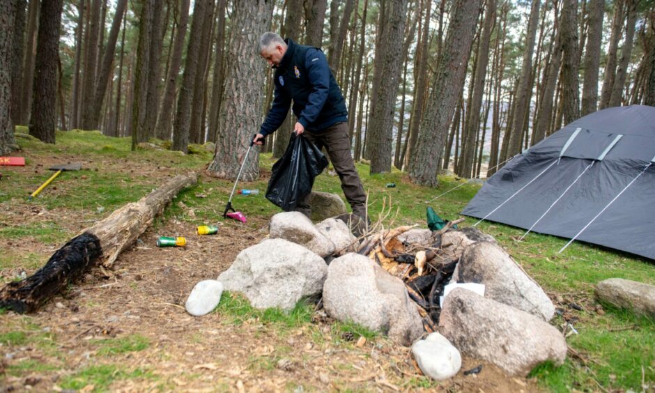 Balmoral estate head ranger Glyn Jones picks up litter at a dirty campsite at Loch Muick. Image: Kath Flannery/DC Thomson