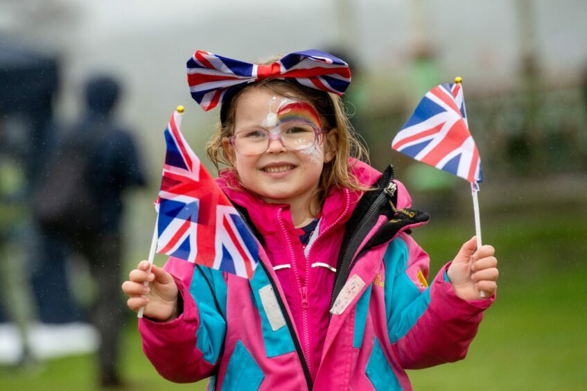 Evelyn Drummond, four, flying the Union Flag with both hands. 