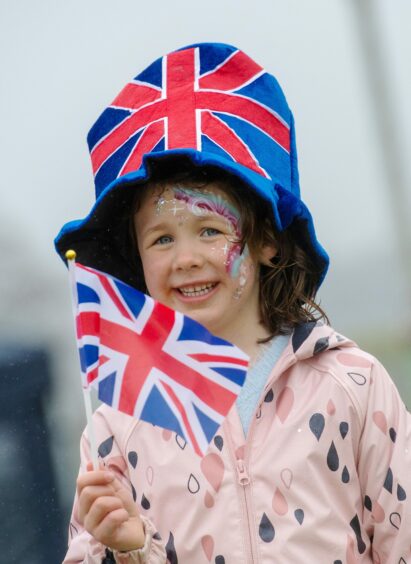 Rebekah Anderson smiling with a Union Jack hat and flag.