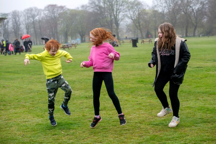 Children dancing in the rain at Aberdeen's Big Lunch in Duthie Park.