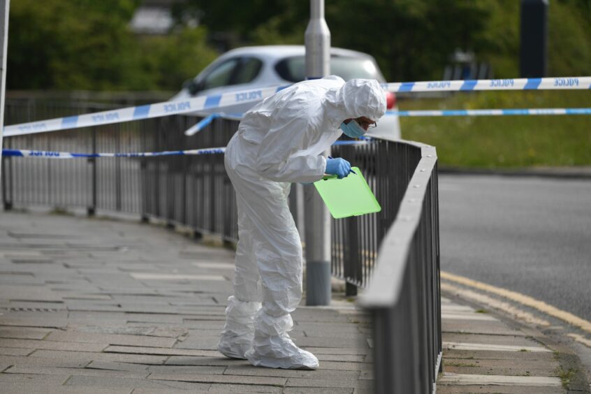 A member of the forensics team inspecting the cordoned off area on Hutcheon Street, Aberdeen. 