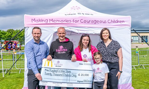 Craig MacLean, Mel Harrison, Jonathan, Anna and Emma Cordiner posing with a cheque in front of a white gazebo