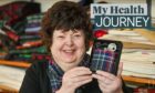 Linda holds up a piece of her specially-designed tartan, which will help raise money for the Aberdeen cardiac unit that saved her life. Image: Jason Hedges/DC Thomson