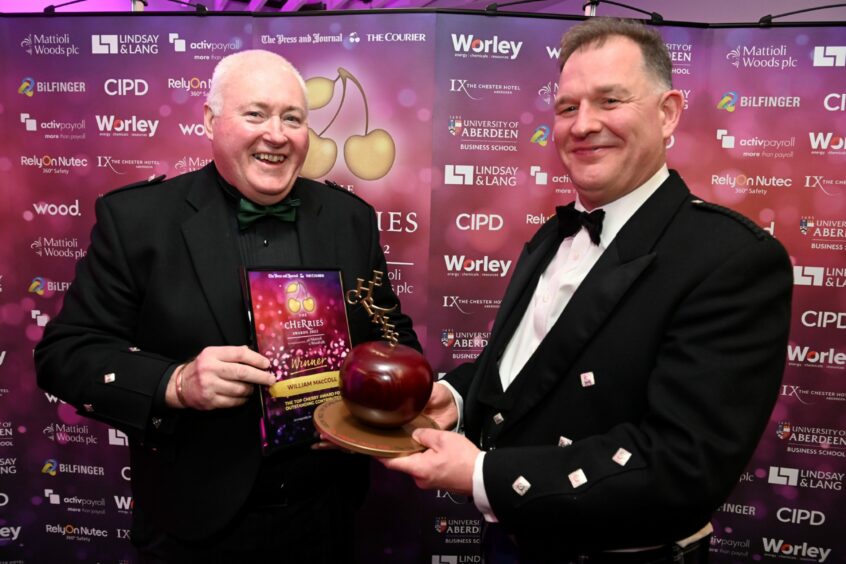 Last year's Top cHeRrywinner Willie MacColl, left, is presented with his trophy by Sean Westwood, employee benefits team director at Mattioli Woods