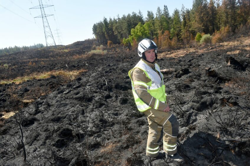 Jamie Thrower, incident commander with Fire and Rescue Scotland pictured amidst the fire stricken woodland near Cannich.