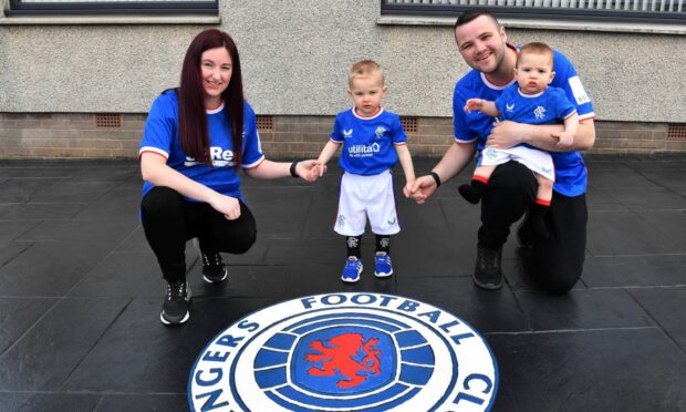 Jordan and Karina Reid with their sons Kayden and Jayden in front of the Rangers crest which takes pride of place in their driveway. Image: Duncan Brown