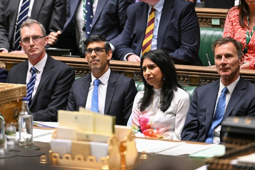 Prime Minister Rishi Sunak sitting next to Home Secretary Suella Braverman