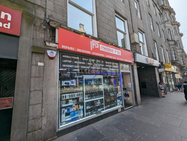 Phone Fix at 33 Union Street is also under consideration by planning enforcement teams in Aberdeen. A gap exposes the innards of the wall behind the sign above the door. Image: Alastair Gossip/DC Thomson.