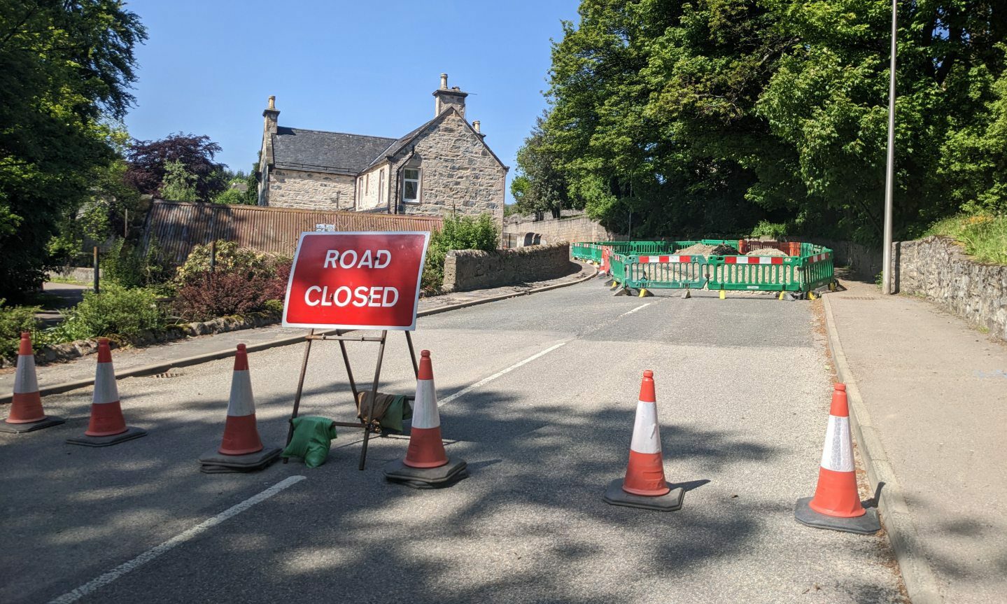 Traffic cones blocking entry to Fife Street with a "road closed" sign. 