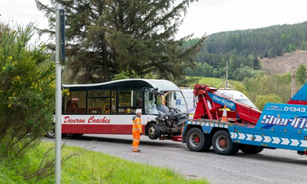 A bus involved in the crash on the A95 being towed with a badly smashed window screen.