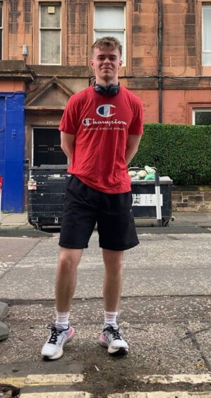 Toby Esslemont-Edwards during a marathon training session standing on the street in a red t-shirt 