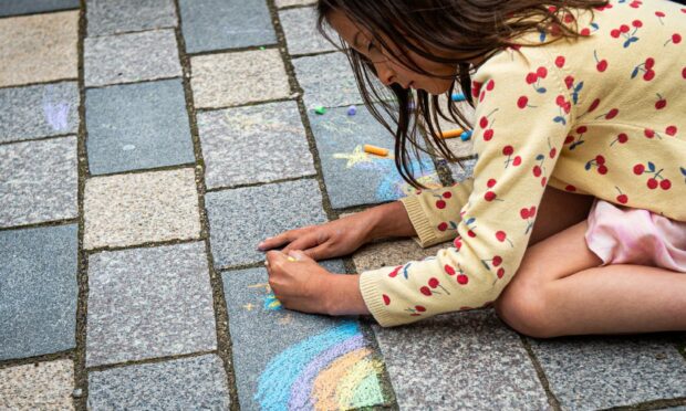 Girl painting the pavement at Marischal Square as part of the Chalk Don't Chalk event.