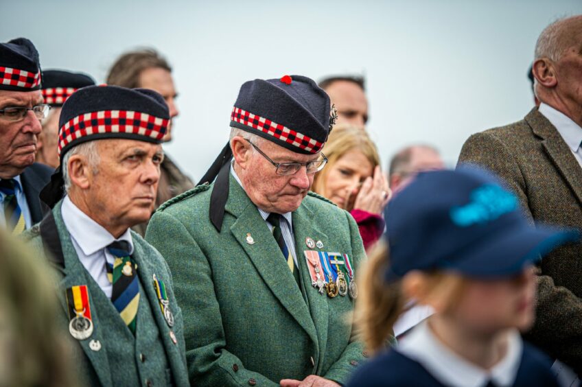A veteran in uniform bows his head during the ceremony 