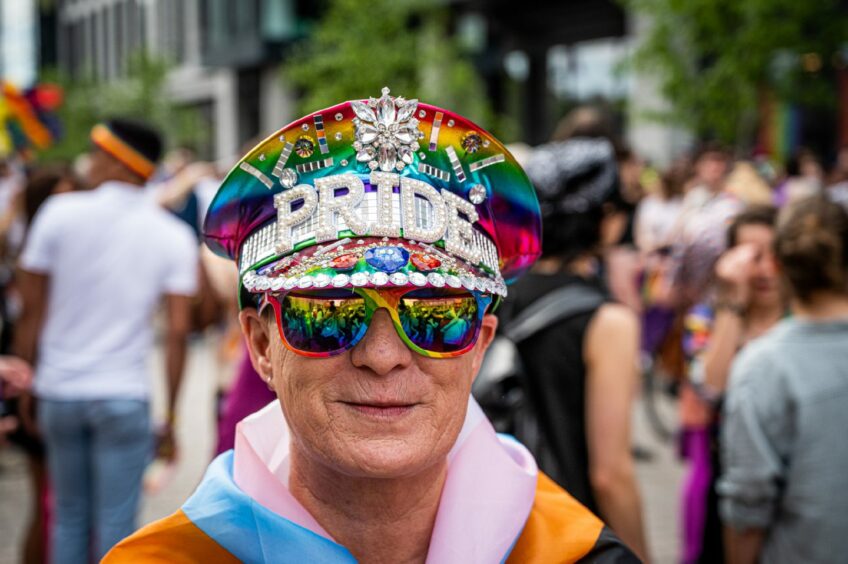 Man wearing a bedazzled 'PRIDE' hat.