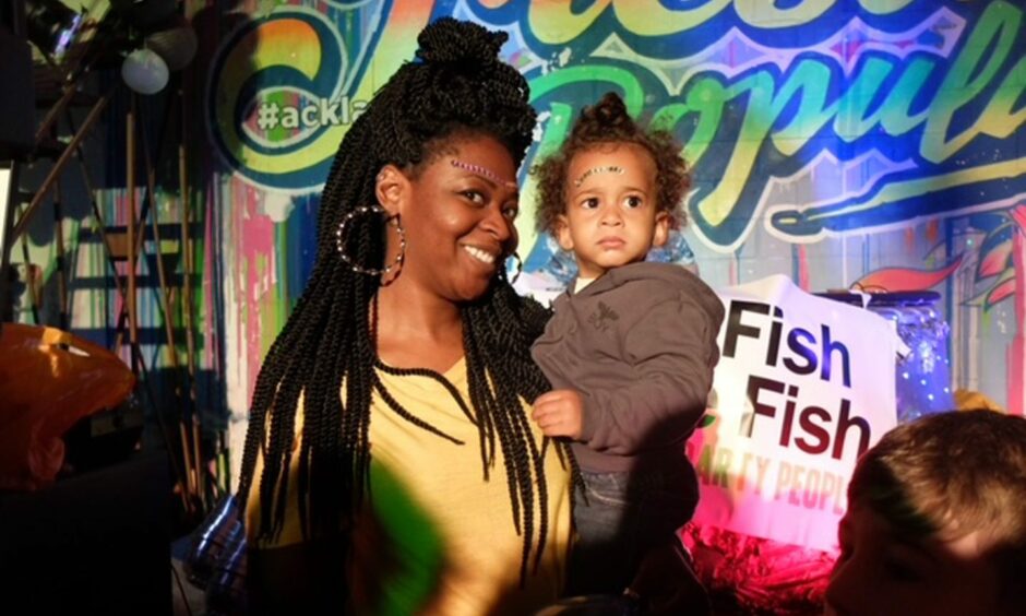 Mother and child smiling at a Big Fish Little Fish family rave event.