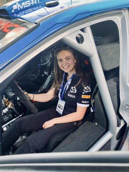 Emily Easton-Page pictured sitting in the driver seat of a rally car. 