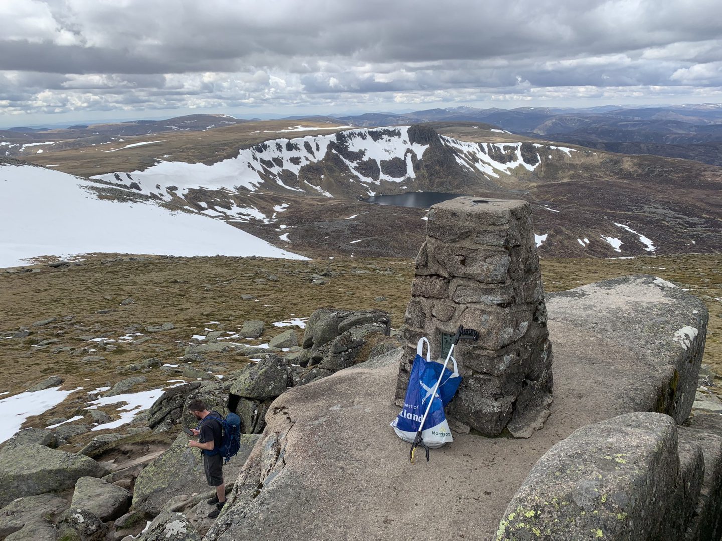 A view from the trig point of Lochnagar, with a bag full of collected litter.