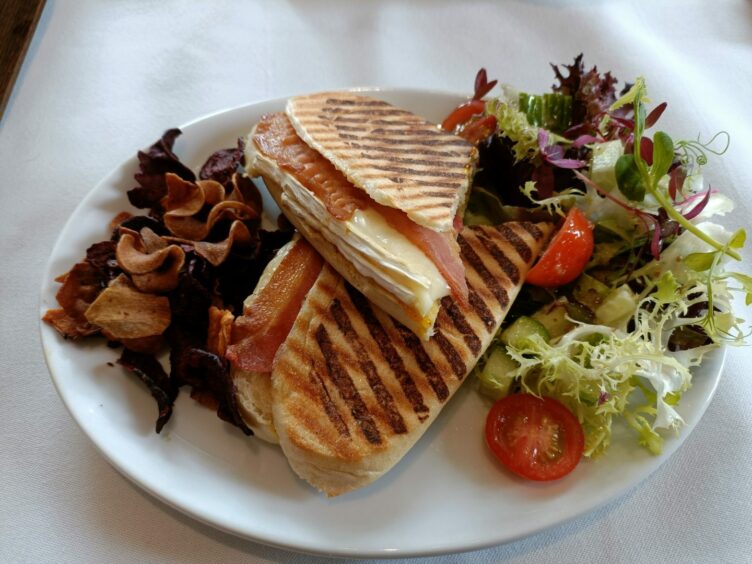 The Orchard Tea Rooms's bacon and brie panini with vegetable crisps and side salad.