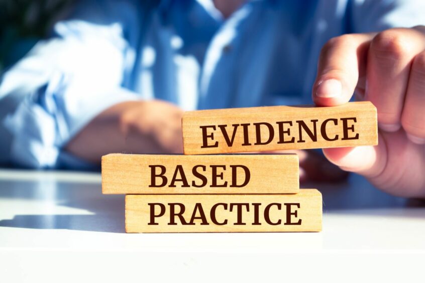 Close up on businessman holding a wooden block with 'Evidence based practice' message