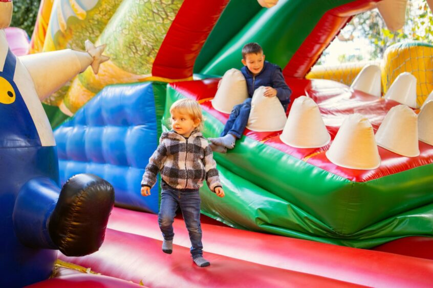 Children having fun on colourful inflatables