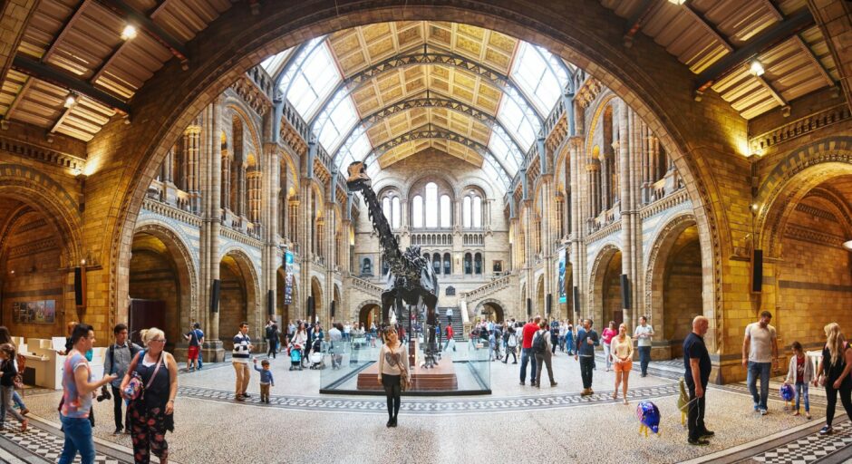 Tourists walk around the grand hall of the Natural History Museum in London. 
