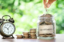 A photo of hand saving money in a jar. Article about how much should I save for retirement.