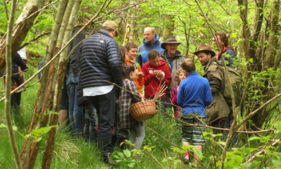 Group of people walking and foraging in nature.