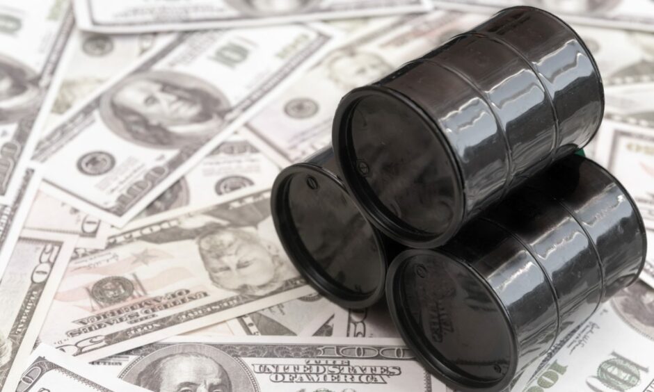 Barrels of oil against the background of American dollars.