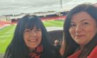 Music fans June McBride and Karen Duguid in the Richard Donald Stand at Pittodrie with pitch behind.