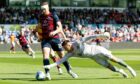 Partick Thistle's David Mitchell tries to claw the ball away from Ross County's Jordan White. Image: SNS.