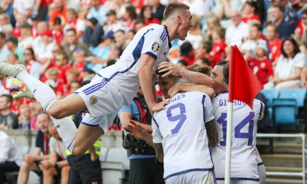 The Scotland players celebrate with Kenny McLean after he makes it 2-1 against Norway. Image: SNS.