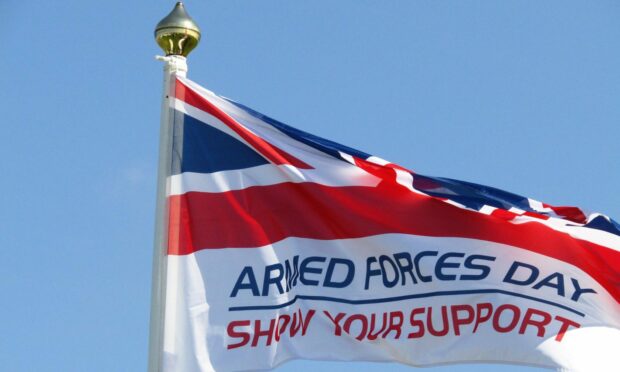 The Armed Forces flag, featuring a union jack, flying at full-mast.