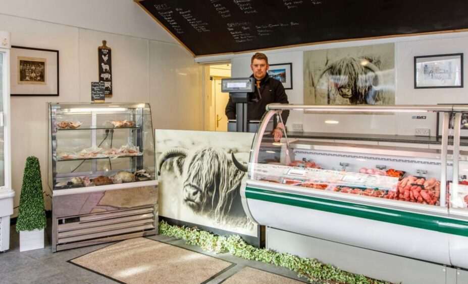 A picture of the butcher standing behind the counter at Chattan Quality Meats