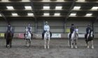 Students on horses in UHI North Highland's indoor yard