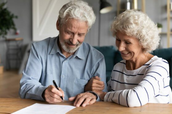 elderly couple signing a document