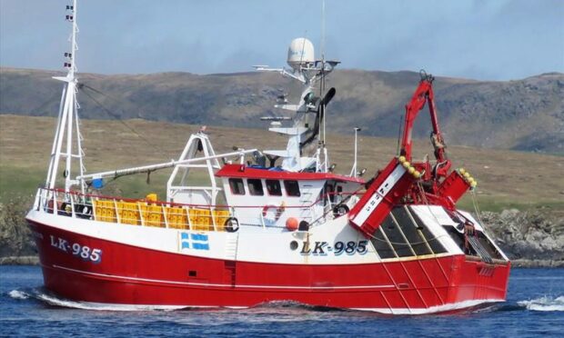 Side-on view of red and white Copius trawler at sea.