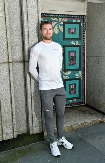 Man in grey tracksuit bottoms and white full-sleeve top.