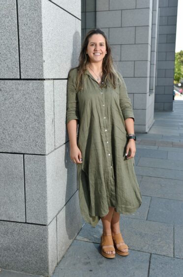 Woman in green buttoned summer dress styled with tan wedges.