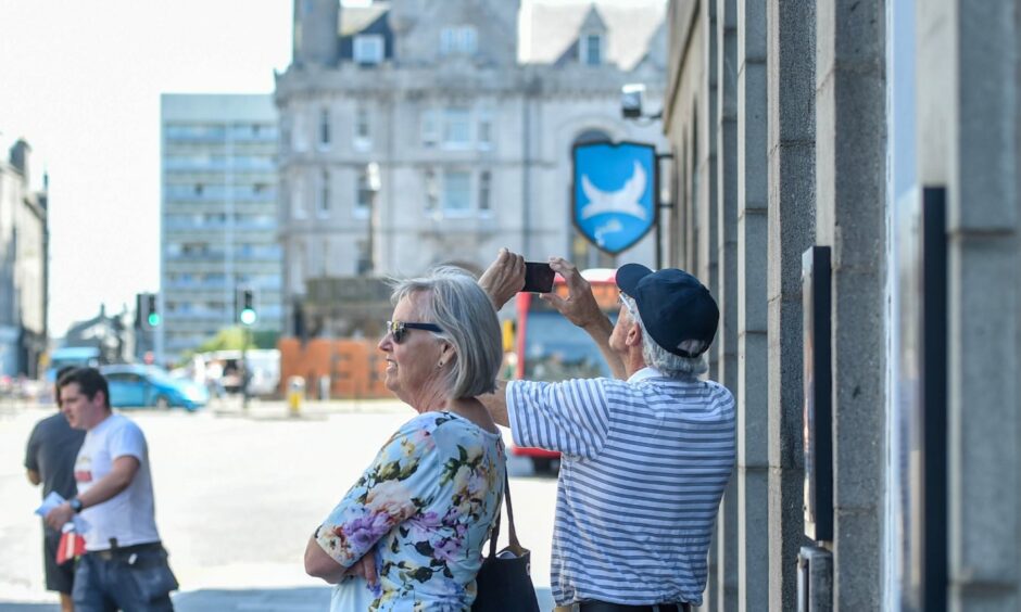 Tourists taking photos of Aberdeen Town House on Union Street. Image: Darrell Benns/DC Thomson