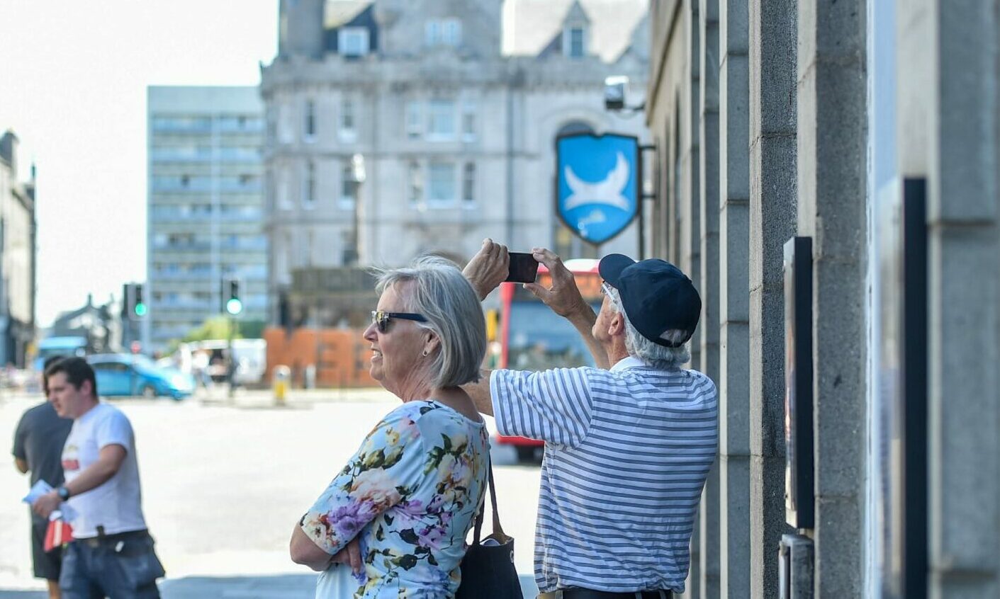 Tourists taking photos of Aberdeen Town House on Union Street. Image: Darrell Benns/DC Thomson