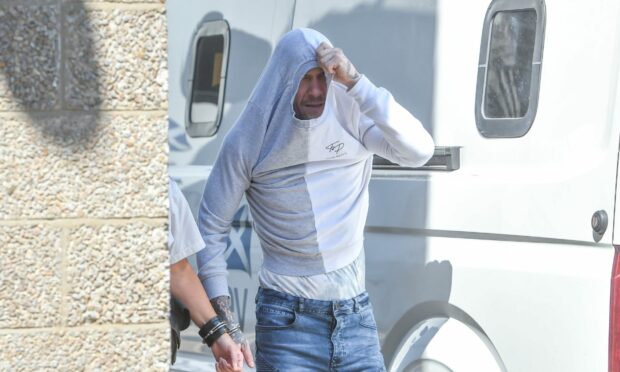 Aurimas Samalkis hid his face as he left Aberdeen Sheriff Court. Image: DC Thomson