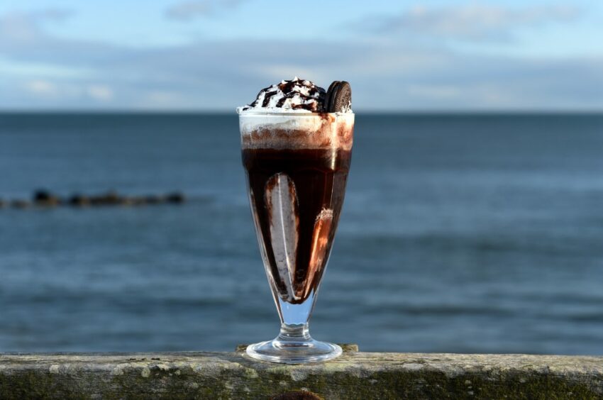 Barking Mad oreo milkshake with a backdrop of the ocean.